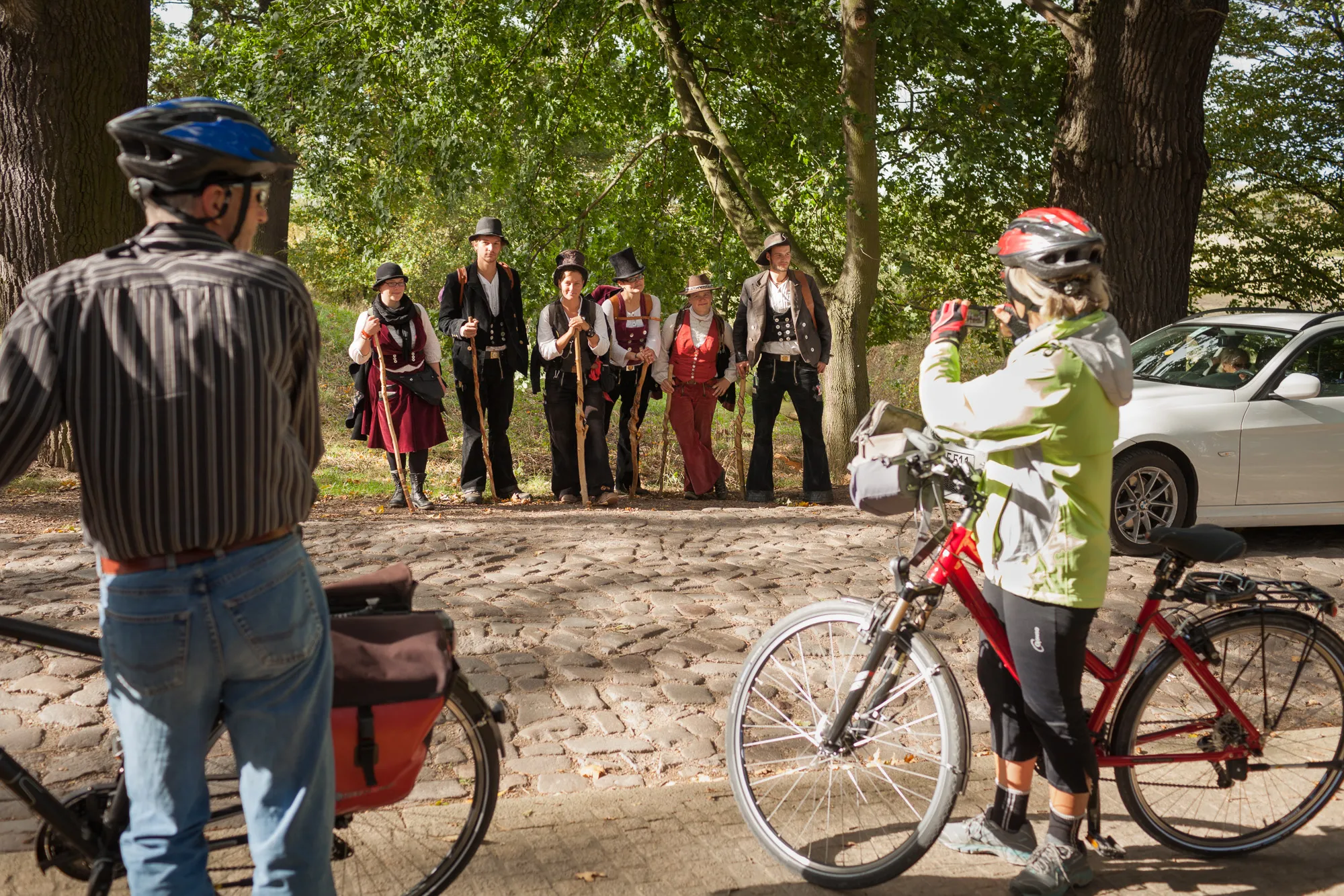 Frau auf der Walz unterwegs mit einer Gruppe von Wandergesellen in der alltäglichen Begegnung mit Passanten