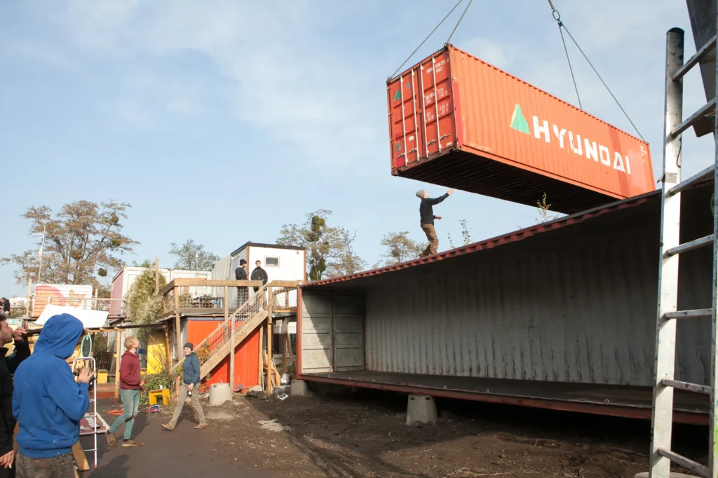 Umlagerung der gebrauchten Überseecontainer per Kran vor dem Ausbau auf dem Platzprojekt Hannover im Rahmen eines soziokulturellen Projekts