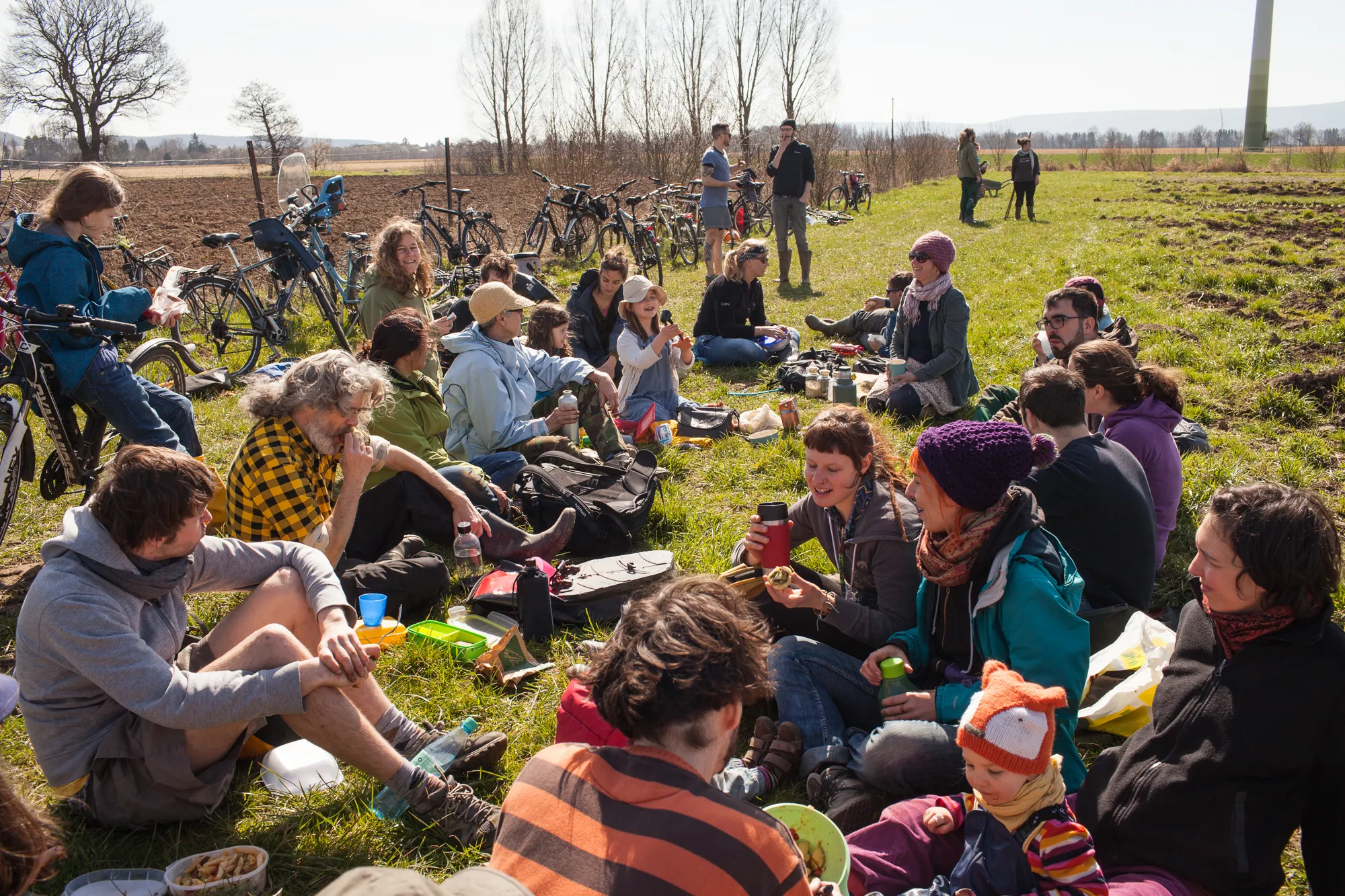 Mitglieder*innen bei der Pause auf dem Feld – Arbeitssituation aus der landwirtschaftlichen Praxis der Solidarischen Landwirtschaft Wildwuchs