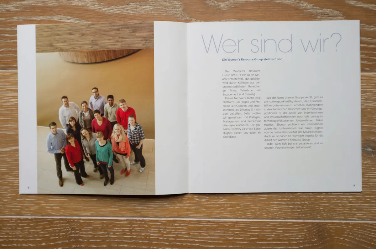 Aufgeschlagene Broschüre mit einem Gruppenporträt der Mitarbeitenden